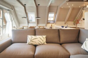 Um espaço de estar acolhedor estilo loft, com um sofá e uma mesa de jantar.