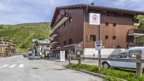 Un hotel con fachada de madera, balcones y un cartel que indica restaurante y bar.