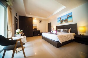 A modern hotel room with a large bed, a desk, and a chair. - Q Victory Patong (Patong)