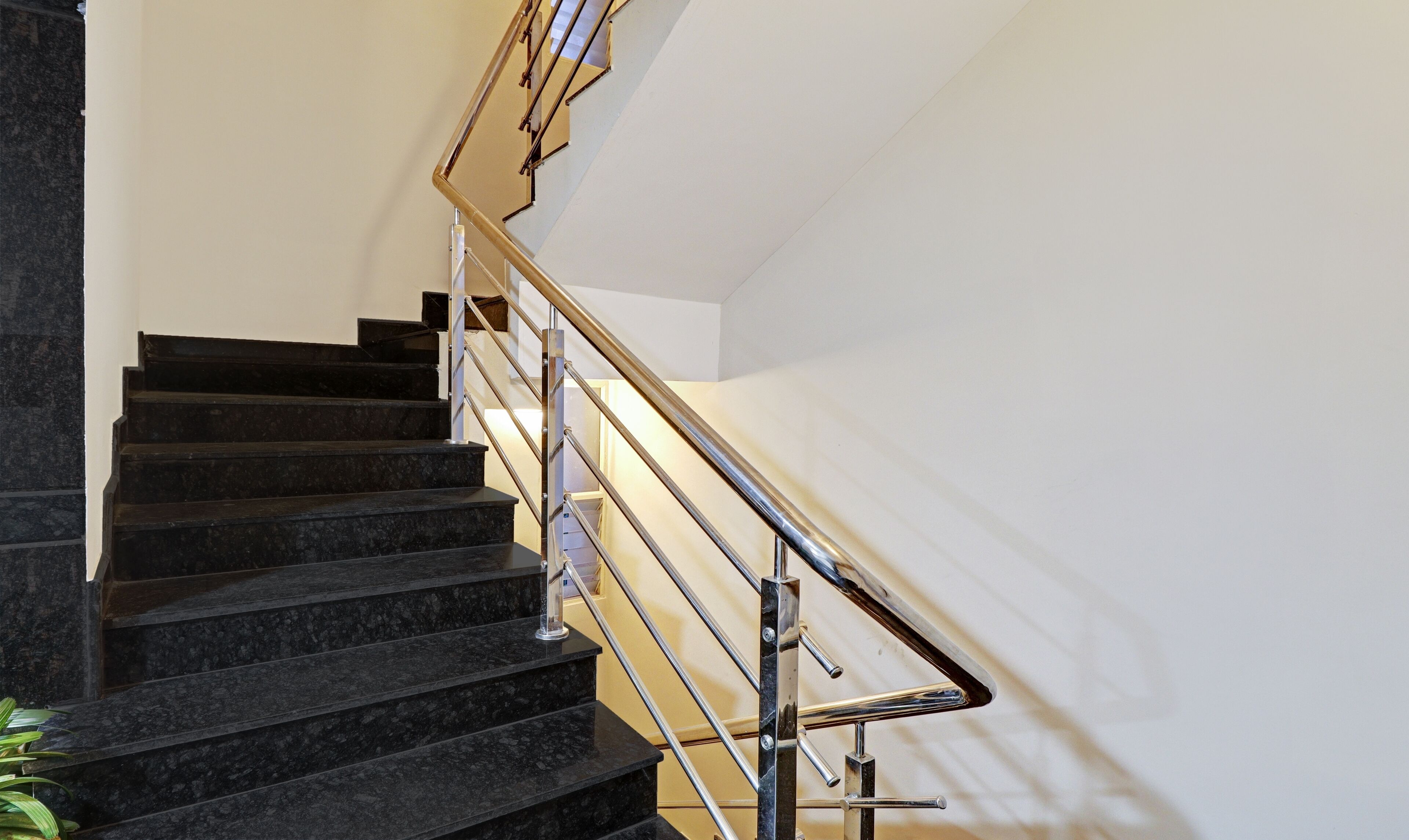A staircase with black marble steps and a metal handrail.