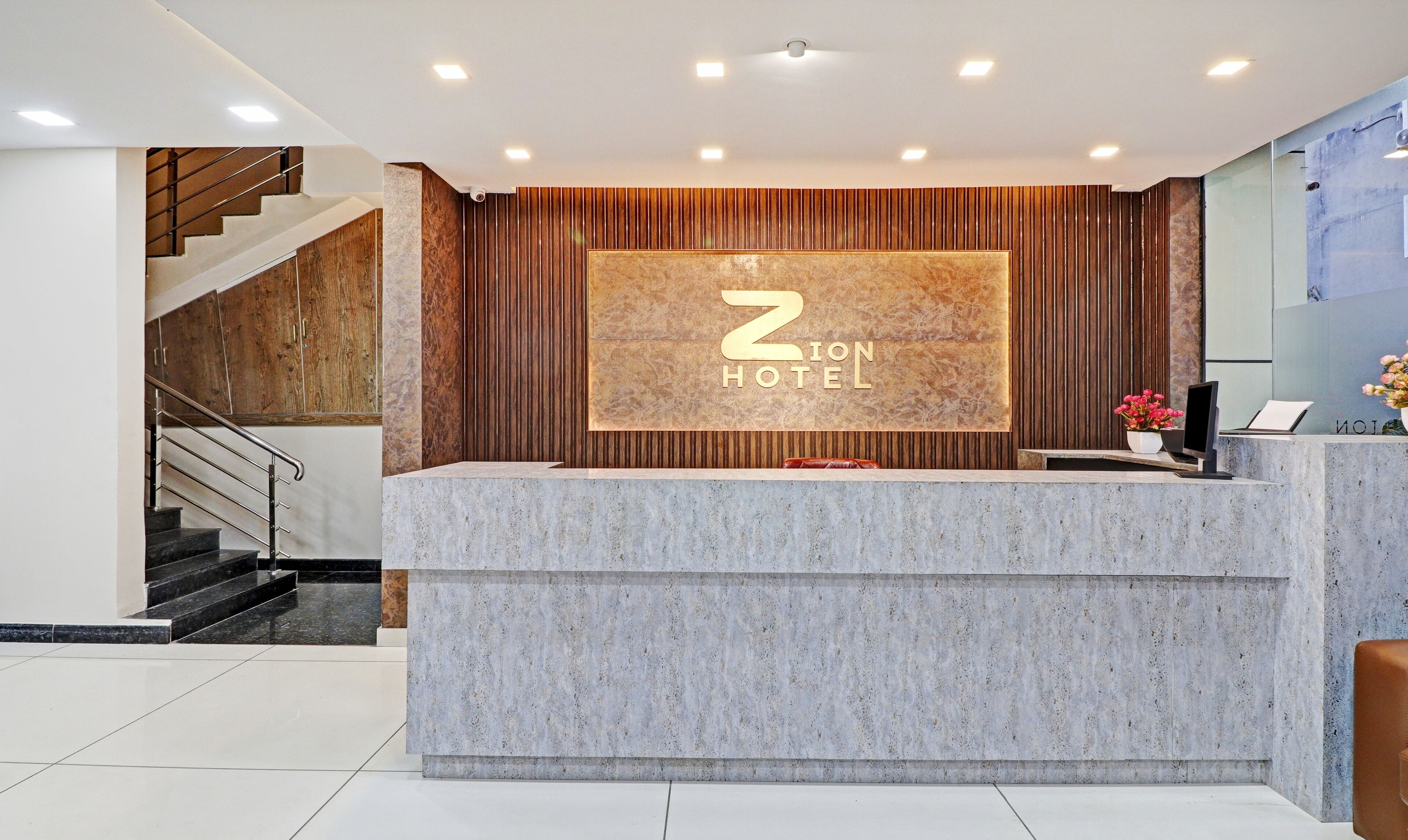 A hotel reception desk with a large sign reading "ZION HOTEL" and a modern interior design.