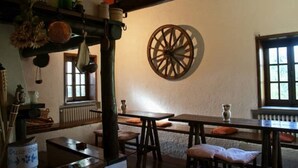 Un interior rústico con vigas de madera, un gran adorno circular en la pared y muebles tradicionales.