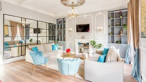 A spacious living room with a large mirror, a fireplace, and a television. - Merveil - Luxury Suite - Opera - Septembre I (Paris)