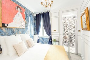 A bedroom with a bed, a chandelier, a window with curtains, and a door with patterned glass. - Merveil - Luxury Suite - Opera - Septembre I (Paris)
