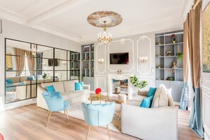 Een ruime woonkamer met een grote spiegel, een open haard en een televisie.