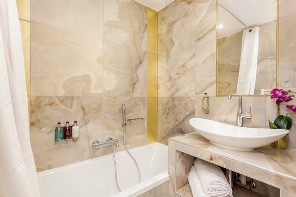 A modern bathroom with a bathtub, a sink, and a mirror. - Merveil - Luxury Suite - Opera - Septembre I (Paris)