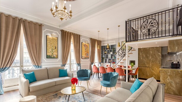 A spacious living room with a sofa, chairs, and a coffee table. There is a staircase leading to an upper level with a balcony. - Merveil - Luxury Suite - Opera - Septembre I (Paris)