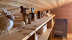Una repisa de madera con varios objetos decorativos, incluyendo un peluche, una figura de madera y cerámica.