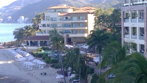 A beachfront hotel with multiple balconies, a pool area, and beachside seating. - Beautiful, Luxurious Puerto Vallarta Resort (Puerto Vallarta, Jalisco)