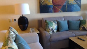 A living room with a sofa, a table, a lamp, a phone, and a painting on the wall. - Beautiful, Luxurious Puerto Vallarta Resort (Puerto Vallarta, Jalisco)