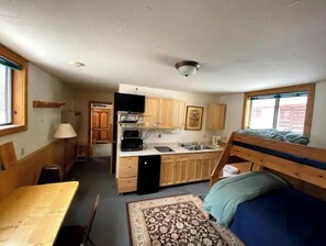 Enjoy a compact space with a kitchenette, dining area, and cozy sleeping space featuring a bunk bed.