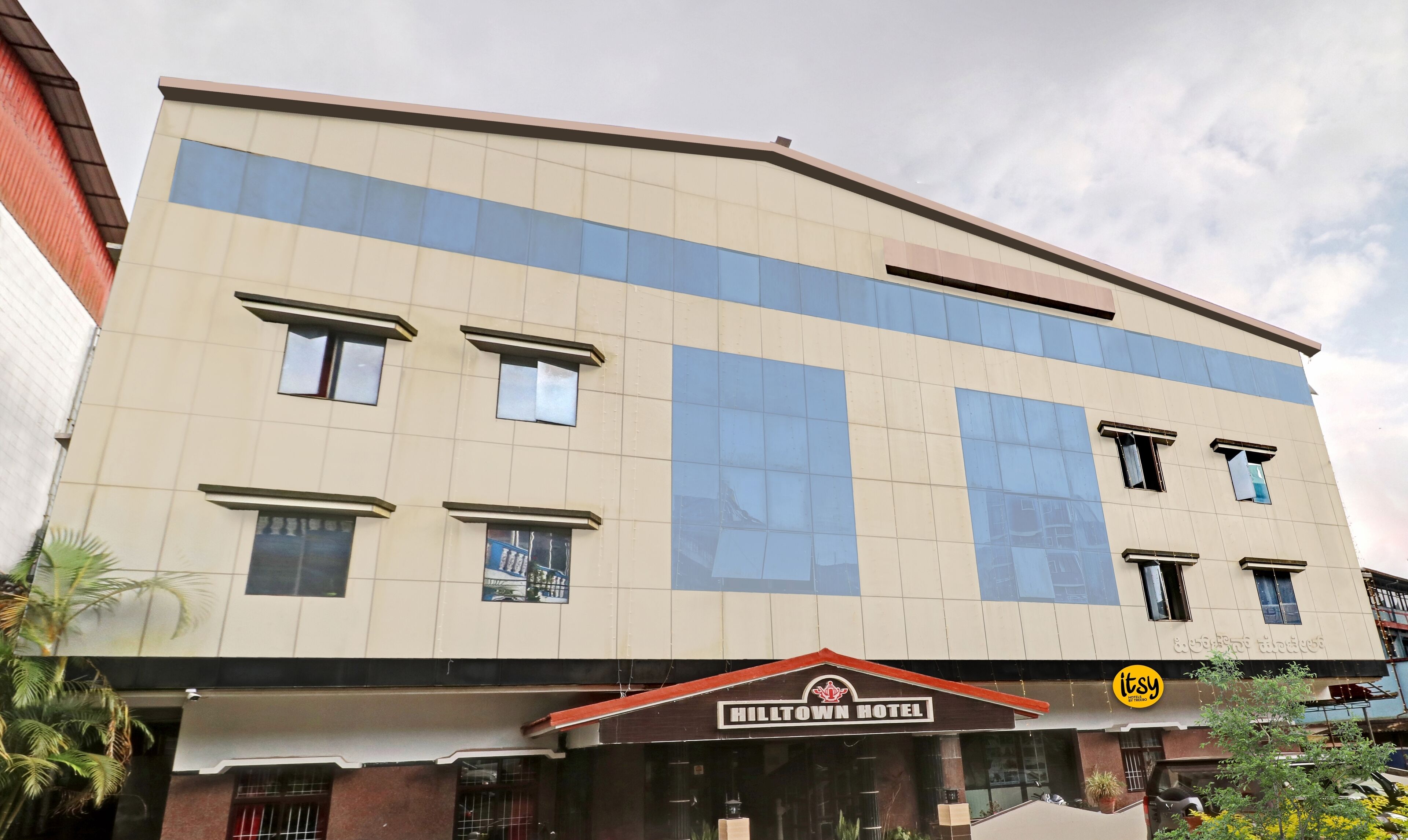 Un hotel con fachada moderna, varias ventanas y un cartel que indica que es el Hotel Hilltown.