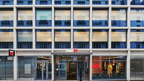 A modern building with a glass facade, multiple balconies, and a storefront labeled "Citizen."