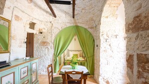 A rustic dining area with a table, chairs, and a green curtain.