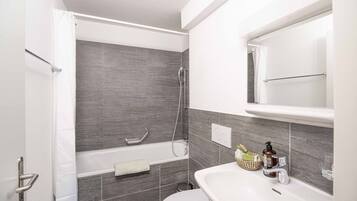 Une salle de bain moderne avec une baignoire, des toilettes et un lavabo.