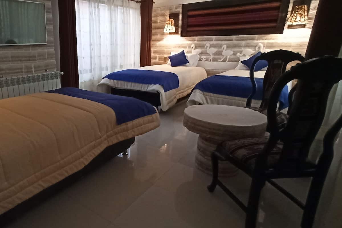 Een hotelkamer met twee bedden, een ronde tafel en een televisie.