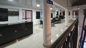 A spacious lobby with a reception desk, seating area, and a sign indicating a bar.