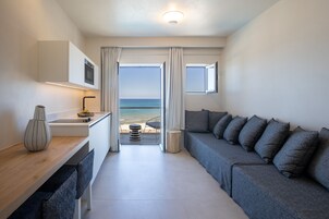 Una habitación moderna y funcional con sofá, comedor y vistas al mar.