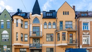 A row of multi-story buildings with distinct architectural styles, including a building with a pointed roof and another with a rounded balcony. - 1br apartment with balcony and sea view (Helsinki)
