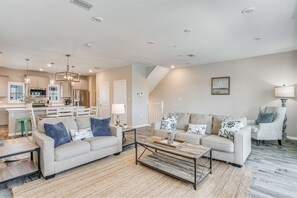 A spacious living area with a sofa set, a coffee table, and a dining table.