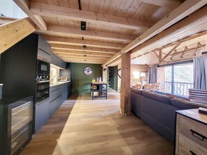 Un interno in legno con una cucina, zona pranzo e un divano.