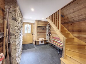 Cozy retreat with a high ceiling, wooden beams, and a stone wall.