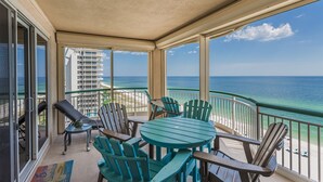 Ein überdachter Balkon mit Blick auf das Meer, ausgestattet mit einem Tisch und Stühlen.