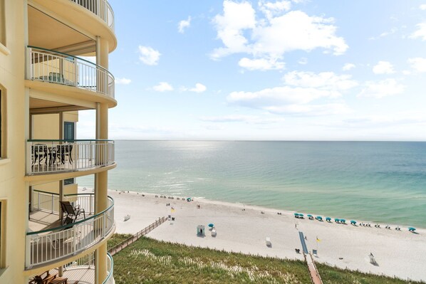A multi-story hotel with balconies overlooking a beach.