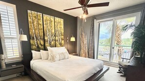 A spacious bedroom with a large bed, a ceiling fan, and a view of the outdoors through a sliding glass door. - Beach Colony Tower 2D - Indoor Pool - HASSLE-FREE CHECK OUT (Perdido Key)
