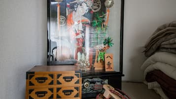 A room with a traditional Japanese altar, a wooden chest, and a futon bed.