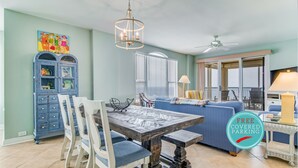 Ein Essbereich mit Holztisch und Stühlen, einem blauen Schrank und einem Deckenventilator.