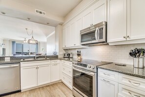 Enjoy cooking in this well-equipped kitchen with a central island, oven, and microwave.