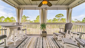 A covered porch with white wooden furniture, including chairs and a table, and a ceiling fan. - Lost Key Villas Golf & Beach Club ~CS'ta on the Key -  NO HASSLE CHECK OUT (Pensacola)