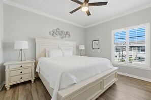 A bedroom with a bed, nightstands, a ceiling fan, a window with blinds, and a wall decoration. - NEW LISTING! Lost Key Golf & Beach Club ~Kokomo - NO HASSLE CHECK OUT (Pensacola)