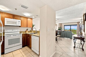 A modern kitchen with built-in appliances, a dining area with a view, and a spacious living room.