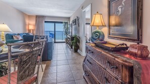 A spacious living area with a balcony, a sofa, a coffee table, and a decorative lamp.
