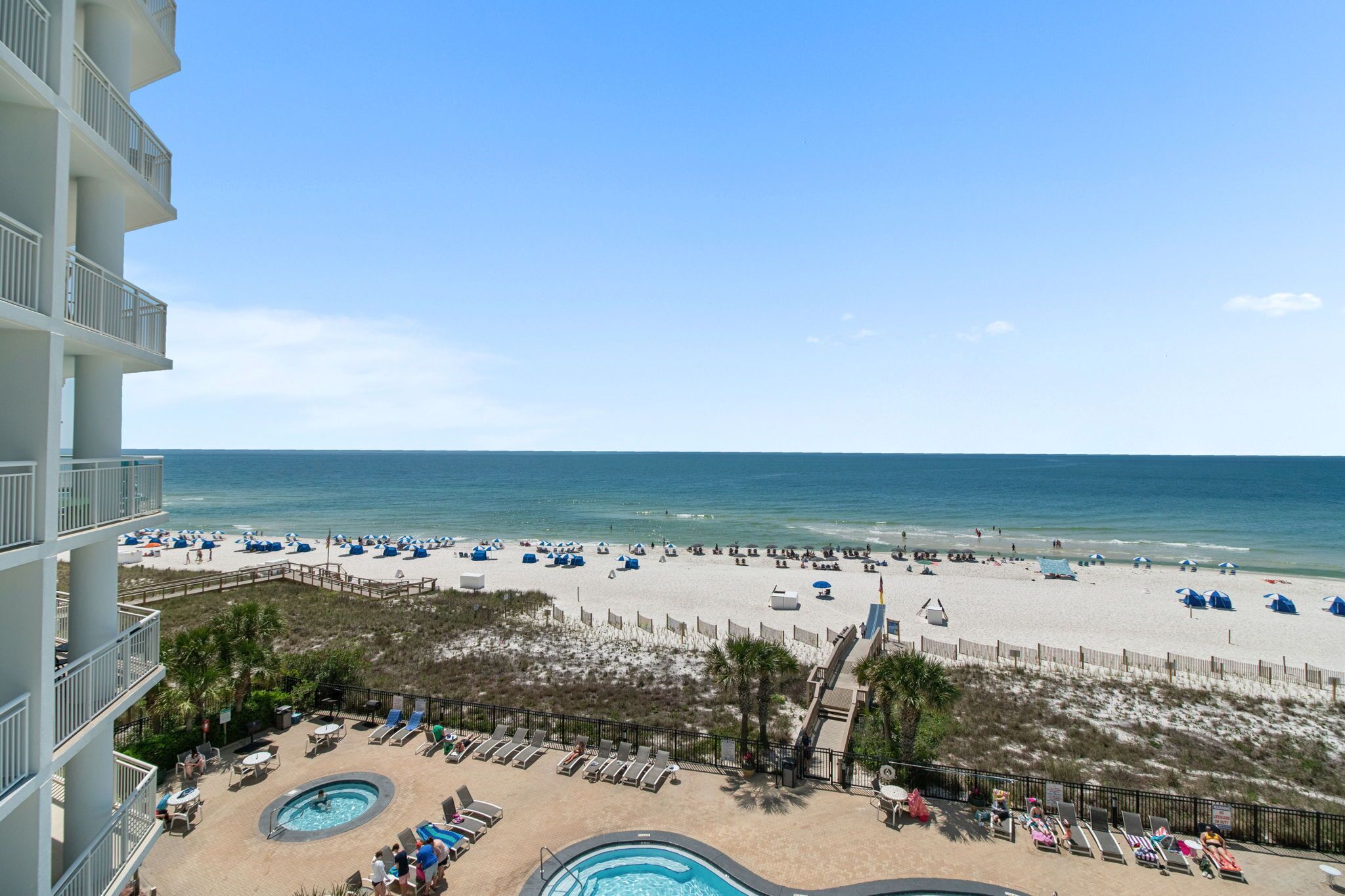 A resort with a pool, beach, and ocean view.
