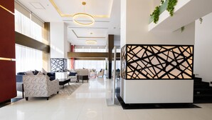 A modern lobby with a reception desk, seating area, and large windows. - MIRA BUSINESS HOTEL (Riyadh)