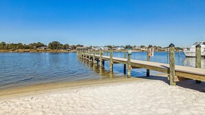 A wooden pier extending into calm water, leading to a sandy beach. - SAILMAKER 1001 - Ole River Views -NO HASSLE CHECK OUT (Pensacola)