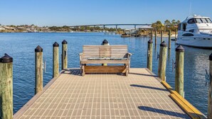 A wooden dock with a bench, wooden posts, and a white yacht docked at the end. - SAILMAKER 1001 - Ole River Views -NO HASSLE CHECK OUT (Pensacola)