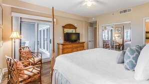 A bedroom with a bed, a television, a dresser, and a chair. - Sandy Key 131 Ground Floor Condo- Beachfront- NO HASSLE CHECK OUT (Pensacola)