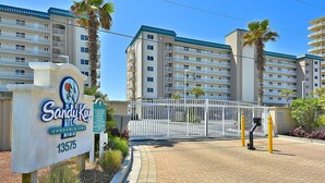 A gated entrance to a building with a sign reading "Sandy Key Condominiums 13575". - Sandy Key 235 Second floor -Beachfront view -NO HASSLE CHECK OUT (Pensacola)