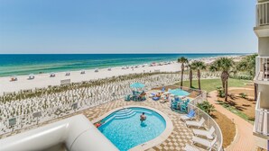 A pool area with a view of the beach, lounge chairs, and umbrellas. - Sandy Key 334 third floor -Beachfront view -NO HASSLE CHECK OUT (Pensacola)