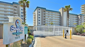 A gated entrance to a building complex with a sign indicating 'Candy Key Condominiums 13575'.