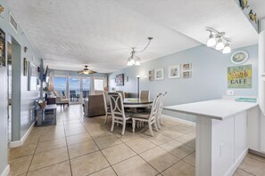 A spacious kitchen with a dining area, a ceiling fan, and a view to the outside. - Sandy Key 415 4th floor -Beachfront view -NO HASSLE CHECK OUT (Pensacola)