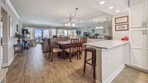 A spacious kitchen with wooden flooring, a central island, and pendant lighting. - NEW LISTING! Sandy Key 515 5th floor -Beachfront view -NO HASSLE CHECK OUT (Pensacola)