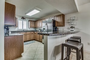 Enjoy cooking in this well-equipped kitchen with a spacious island, large refrigerator, oven, and dishwasher.