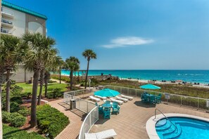 Relax by the oceanfront pool surrounded by lounge chairs and umbrellas.