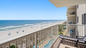 A balcony with a view of a beach and ocean.