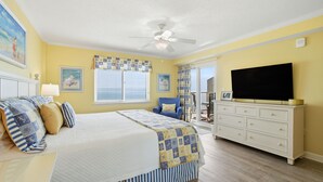 A bedroom with a bed, a dresser, a television, and a ceiling fan. - Sandy Key 8th floor -Beachfront view -NO HASSLE CHECK OUT (Pensacola)